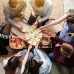 friends sharing pizza in apartment
