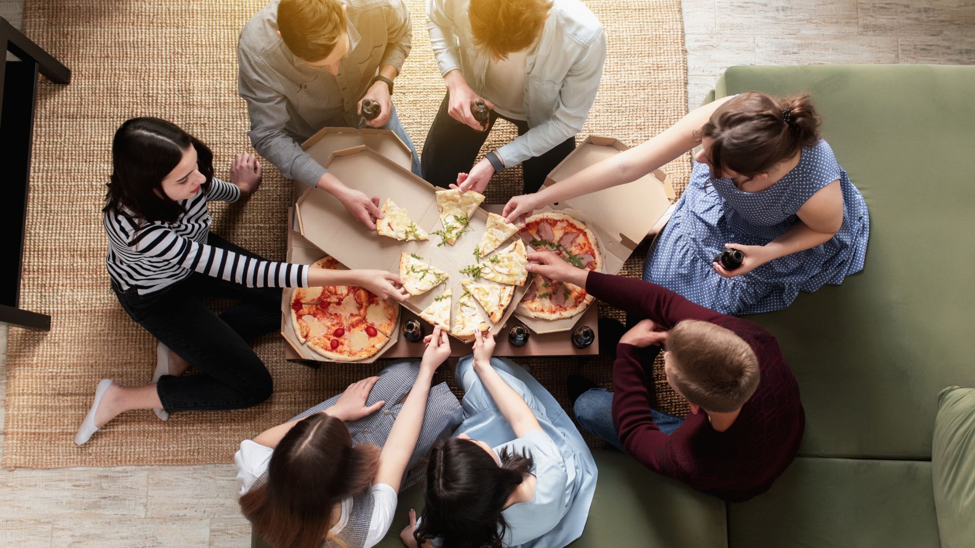 friends sharing pizza in apartment