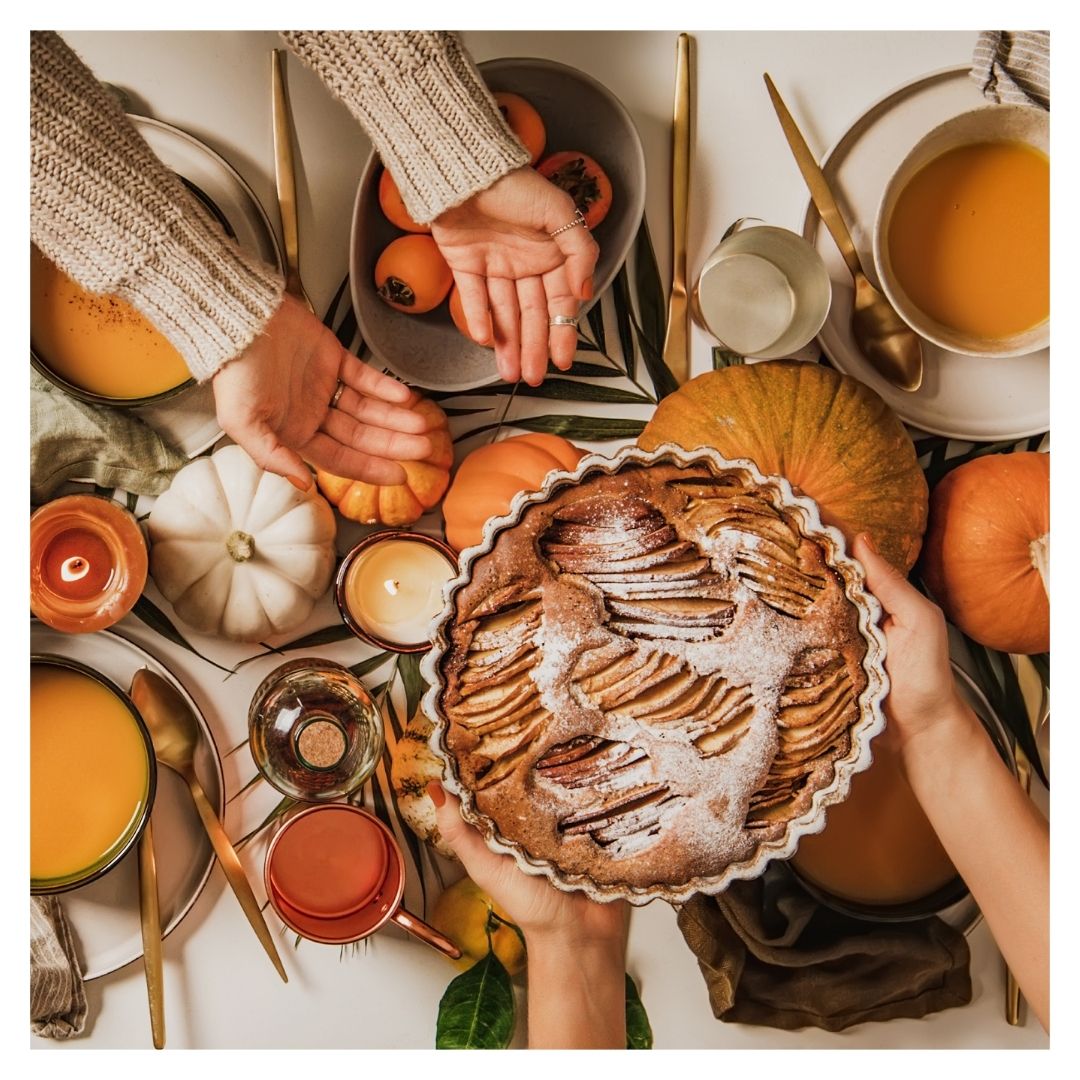 handling an apple pie over a table decorated for fall