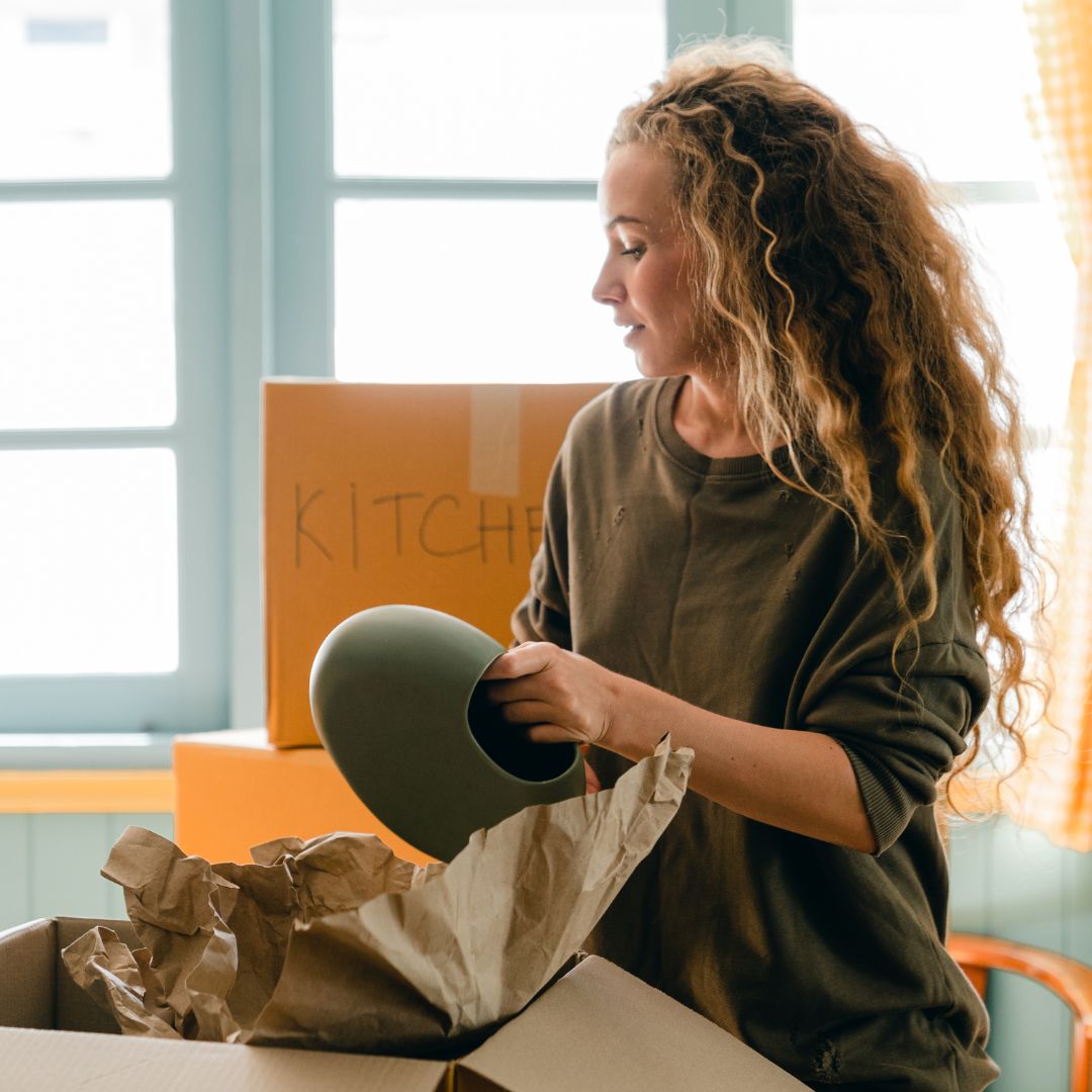 Woman unpacking boxes in new kitchen