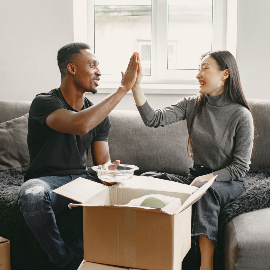 Man and woman high five while unpacking