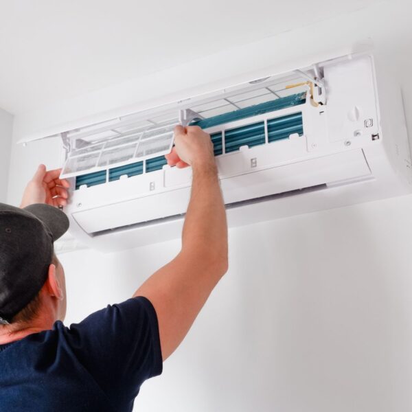 person fixing an AC unit