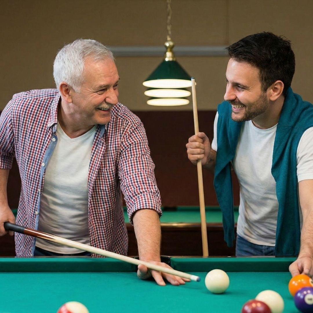 Two neighbors smiling and chatting while playing billiards.