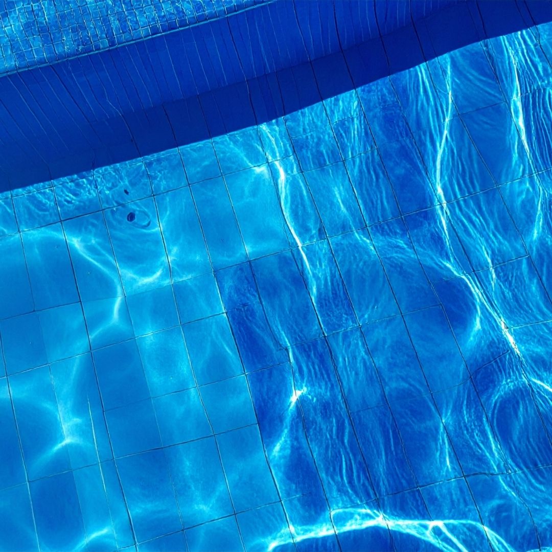 A sunny view of a shimmering blue saltwater swimming pool.